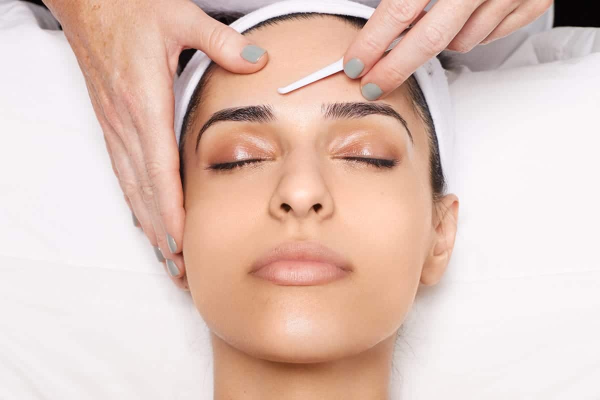 eyebrow waxing. removal of excess hair from the eyebrows